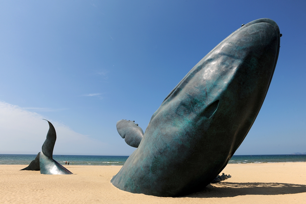 Bronze Whale sculpture in beach